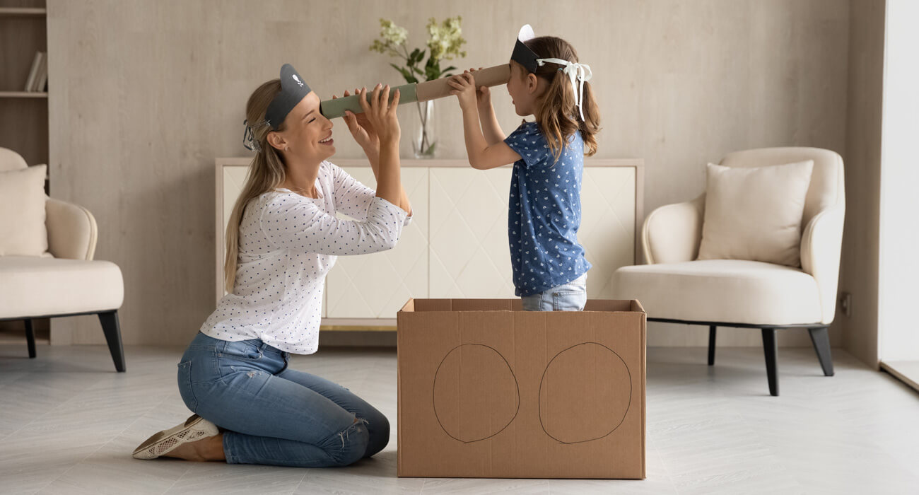 Mum and daughter playing with cardboard to illustrate sustainability