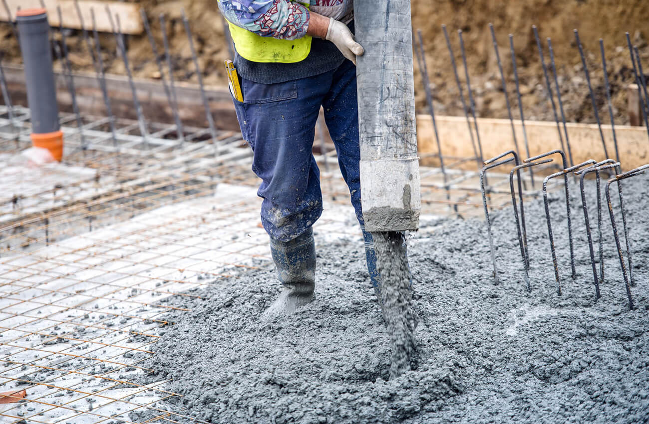 Concrete being poured over compressible void formers on a foundation